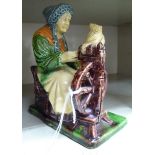 A late 19thC moulded pottery figure, a seated woman working at a spinning wheel 6.