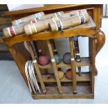 An early 20thC rustically constructed pine croquet stand, containing six mallets,