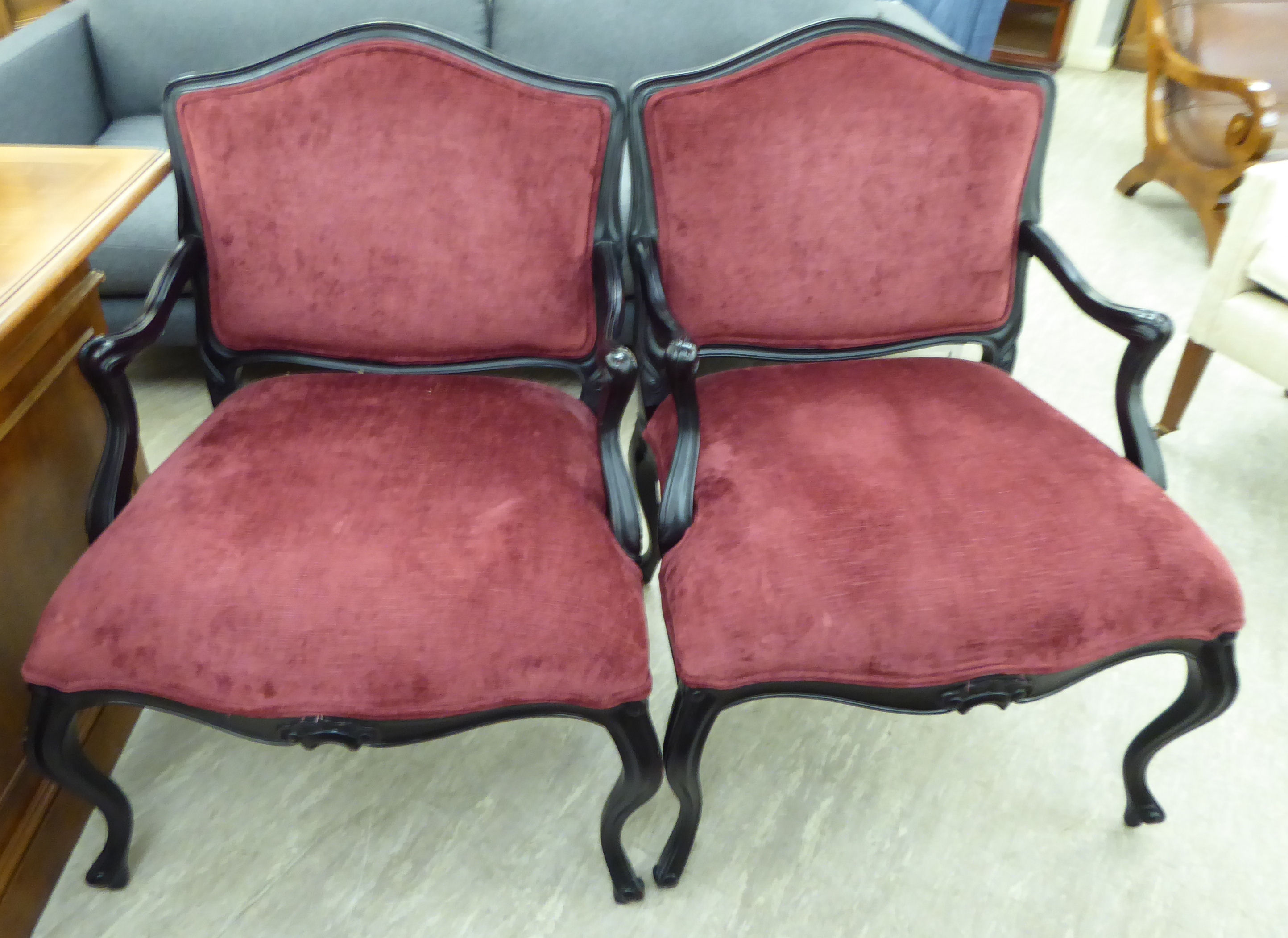 A pair of Louis XV design ebonised framed salon chairs,