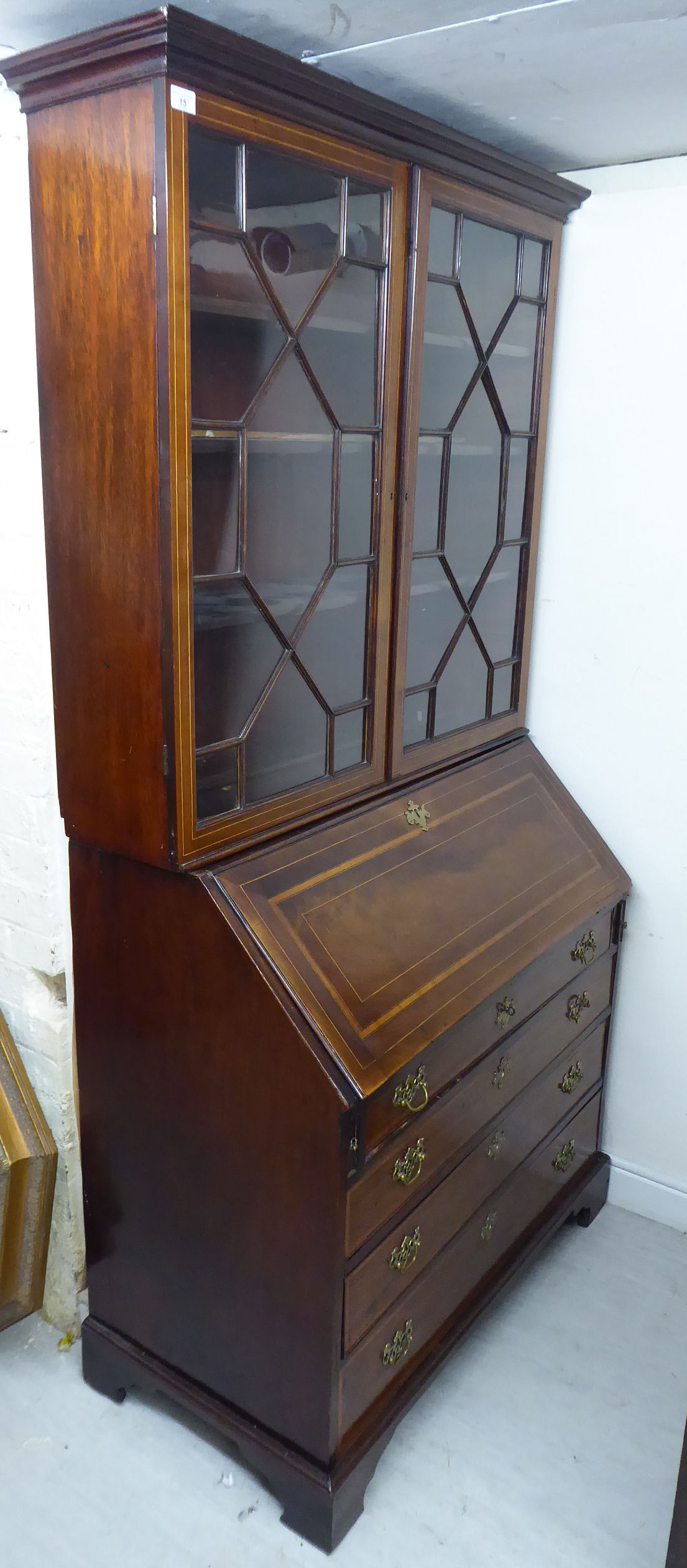 An early 19thC string inlaid mahogany bureau bookcase, the superstructure with a moulded cornice,