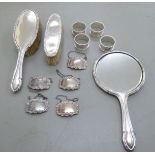 A three piece silver backed dressing table set comprising two brushes and a hand mirror;