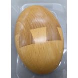 An Ercol bi-coloured oak and elm ovoid shaped paperweight bears a printed paper label OS10