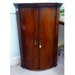 A George III stained oak corner cabinet with panelled doors and bracket feet 38''h 26''w