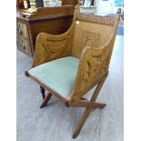 An early 20thC Arts & Crafts light oak framed ecclesiastic's chair, the high,