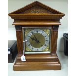 A 1920s light oak cased bracket clock, having an architectural pediment,