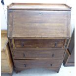 A 1920s oak student's bureau with a fall flap, over three graduated drawers,