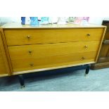 A G-Plan light oak three drawer dressing chest, raised on ebonised,
