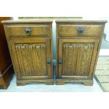 A pair of modern oak bedside cabinets with a single drawer and a linenfold panelled door,