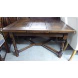 A 1920s/30s oak draw leaf dining table, raised on turned and block legs,