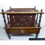 An early 20thC burr walnut finished three division Canterbury with a frieze drawer,