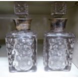 A pair of glass decanters of shouldered box design with stoppers,