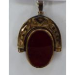 A 10ct gold engraved horseshoe shaped swivel seal pendant,