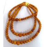 A graduated amber coloured bead triple necklace 11
