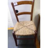 A late Victorian doll's stained beech bar back chair with a woven rush seat,