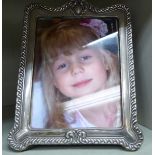 An Edwardian glazed silver photograph frame with a shaped top and moulded surround Chester 1902