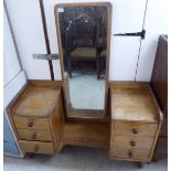 A mid 20thC light oak dressing table with a central mirror, flanked by two banks of three drawers,