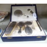 A baby's seven piece, engine turned, silver plated Christening vanity set, comprising two brushes,