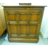 An Ercol light coloured elm corner base unit with a single multi-panelled door,
