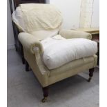A modern easy chair, upholstered in a cream coloured fabric,