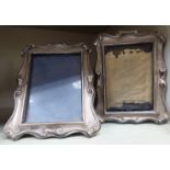 A pair of Edwardian (one glazed) silver photograph frames with rectangular apertures and scrolled
