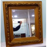 A 20thC 'antique' inspired mirror, the bevelled plate in a deep set,