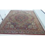 A Persian carpet with a central serpentine outlined medallion,