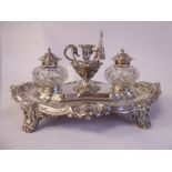 An Edwardian silver standish, the oval, embossed and chased foliate scrolled tray featuring two,