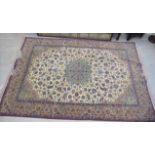 A Persian carpet, decorated with a central floral medallion, bordered by stylised foliage,