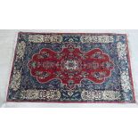 An Oriental rug, decorated with a central serpentine outlined medallion,