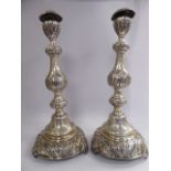 A pair of Edwardian floral embossed silver candlesticks, each with a detachable sconce,