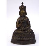 A mid 19thC cast bronze figure, a seated Buddha, wearing a crown, on a triangular plinth 10.