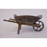 An Indian silver coloured metal wheelbarrow ornament,