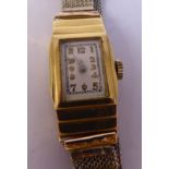 A lady's 18ct gold cased Art Deco style bracelet wristwatch, faced by a rectangular Arabic dial,