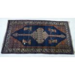 A Persian rug, decorated with a central medallion and four corners of stylised designs,