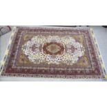 An Iranian part silk/part woollen carpet with a central medallion,