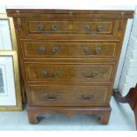 A modern yewwood writing table cabinet with a hinged foldover top and three drawers,