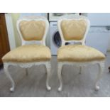 A pair of cream painted showwood framed side chairs, upholstered in floral patterned,
