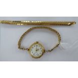 A lady's 9ct gold round cased Art Nouveau inspired wristwatch, cast with lilies,