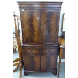 A Georgian style flame mahogany finished cocktail cabinet with a pair of doors,
