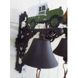 A cast iron door bell, surmounted by a tractor,