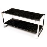 A vintage chromed metal and patterned black glass two tier coffee table