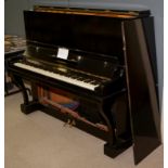 An ebonised upright piano.