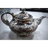 A William IV silver teapot, richly chased and embossed with flowers, foliage and scrolls, George