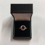 A circular cluster ring, the central red stone with diamonds around, yellow metal stamped 18ct and