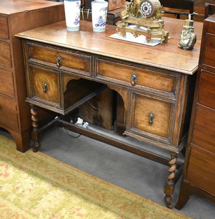 Jacobean style oak dressing table with four drawers raised on barley twist supports united by