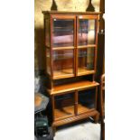 A mahogany display cabinet with two pairs of bevelled glazed doors enclosing shelves (a/f)