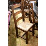 A set of ten heavy oak ladder back and rush seated dining chairs