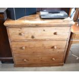 Antique waxed pine chest of three long drawers with turned pulls raised on a shallow plinth base