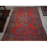 A 1950's Turkey rug with geometric design on red ground and blue border