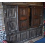 A large linenfold carved oak panel with sliding doors